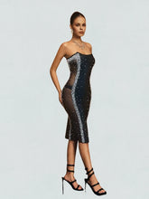 Model wearing a black sequin dress on a light gray background